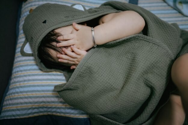 Child with face covered by a hooded towel — representative lifestyle photograph