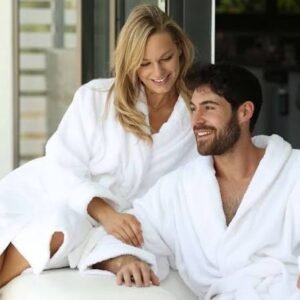 A woman and man wearing white bathrobes