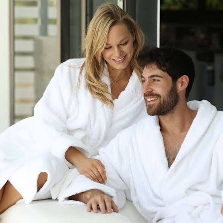 A woman and man wearing white bathrobes