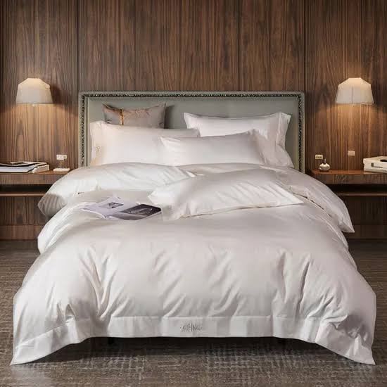 White woven bedding and pillowcases on a hotel bed